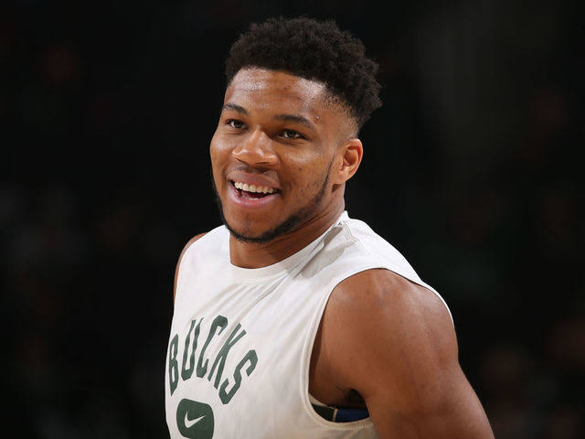 Giannis Antetokounmpo scans QR code on his cell phone for free chicken wings